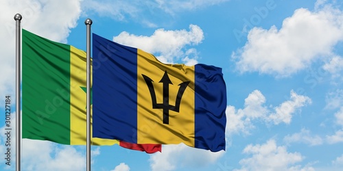 Senegal and Barbados flag waving in the wind against white cloudy blue sky together. Diplomacy concept, international relations.