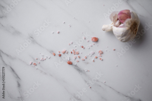 Himalayan salt and garlic on marble background with copy space