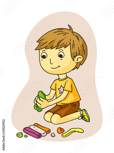 Cute smiling little boy making plasticine figures