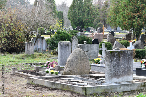 Cemetery graveyard with a big stone cross.Cemetery on cold november day. Orthodox Christian cemeteryAll Saints day at1 nov in the cemetery. Lithuanian cemetary photo