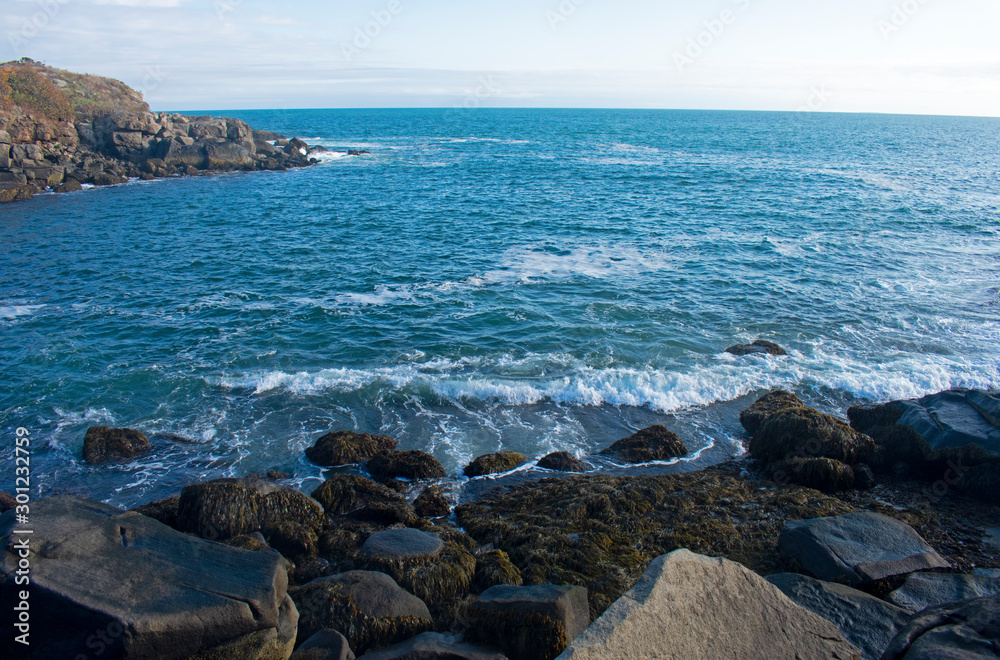 Small waves crashing into rocky shoreline viewed from Cape Neddick, York, Maine, USA. -04