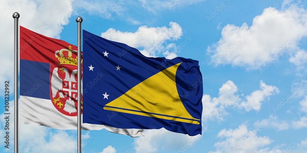 Serbia and Tokelau flag waving in the wind against white cloudy blue sky together. Diplomacy concept, international relations. Serbia and Tokelau flag waving in the wind against white cloudy blue sky together. Diplomacy concept, international relations.