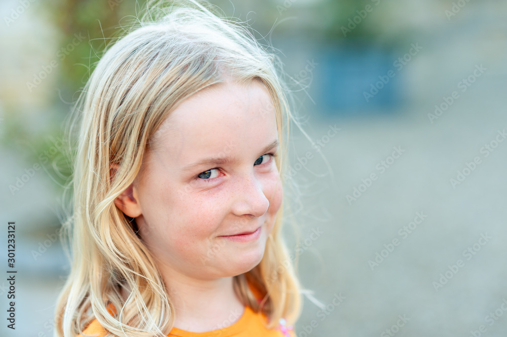 Close up headshot of a young, pretty blonde girl looking at the camera and trying not to laugh Close up headshot of a young, pretty blonde girl looking at the camera and trying not to laugh