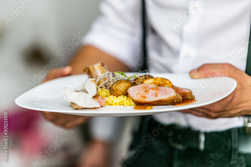 Modern food stylist decorating meal for presentation in restaurant. Closeup of food stylish. Restaurant serving. Close-up on the hand of a waiter carrying food