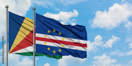 Seychelles and Cape Verde flag waving in the wind against white cloudy blue sky together. Diplomacy concept, international relations.