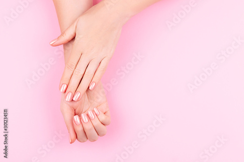 Fototapeta Naklejka Na Ścianę i Meble -  Beautiful Woman Hands on pink backgrounda. Spa and Manicure concept. Female hands with pink manicure. Soft skin skincare concept. Beauty nails.