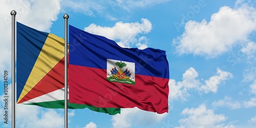 Seychelles and Haiti flag waving in the wind against white cloudy blue sky together. Diplomacy concept, international relations.