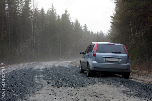 car standing on the side of a forest road © Alexey
