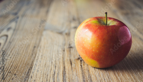 mela rossa singola su fondo legno photo