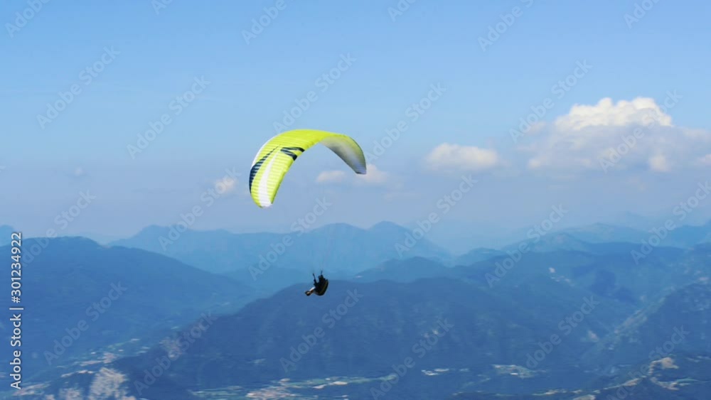 Paraglider flying over the Garda Lake (Lago di Garda or Lago Benaco), Panorama of the gorgeous Garda lake surrounded by mountains. Paragliding is very popular sport in Monte Baldo. Malcesine, Italy