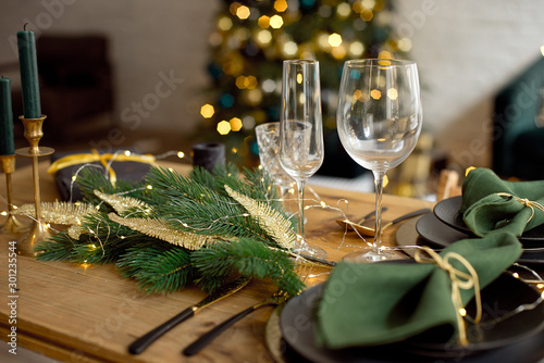 Table served for Christmas dinner in living room, close-up view, table setting, Christmas decoration.