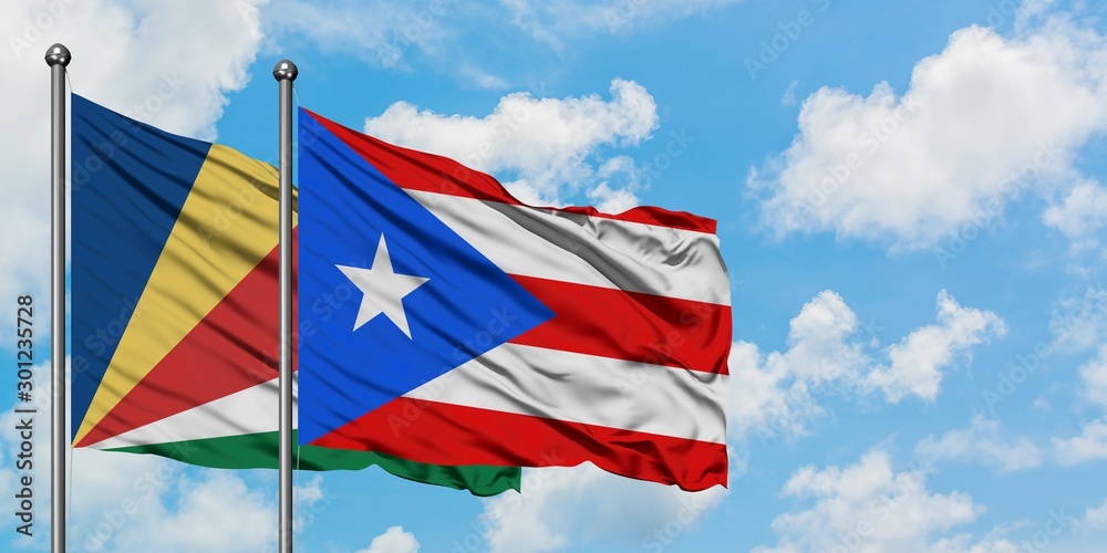 Seychelles and Puerto Rico flag waving in the wind against white cloudy blue sky together. Diplomacy concept, international relations.