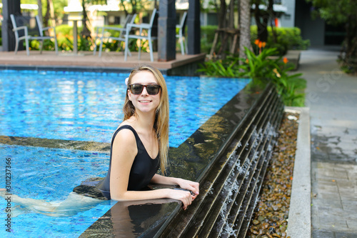 young female looking at camera wearing sunglassses enjoy swimmin photo