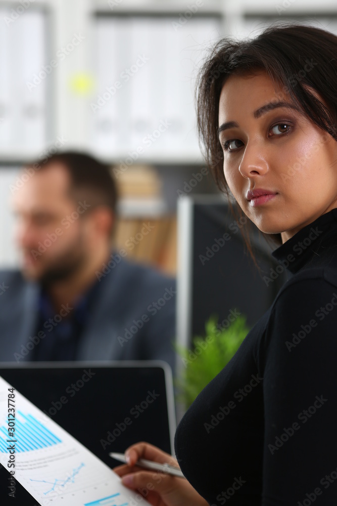 young beautiful woman sit on chair at table in office in cabinet of her boss hold binder in arms young beautiful woman sit on chair at table in office in cabinet of her boss hold binder in arms