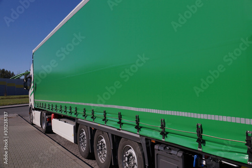 View of the green tarpaulin covering the semi-trailer of the truck. Truck transport.
