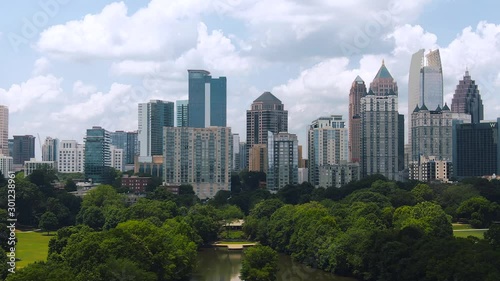 Tight aerial of downtown Atlanta buildings with green trees blue sky and clouds photo