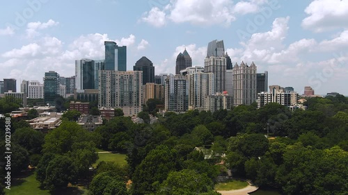 Atlanta skyline aerial flying back over park on bright sunny day blue skies and clouds