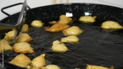 Frying Pettole - Typical dish of South of Italy. Pettole is a traditional christmas south italian food cooked from dough and fried in olive oil, made in Salento, Puglia photo