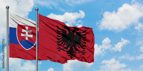 Photography Slovakia and Albania flag waving in the wind against white cloudy blue sky together