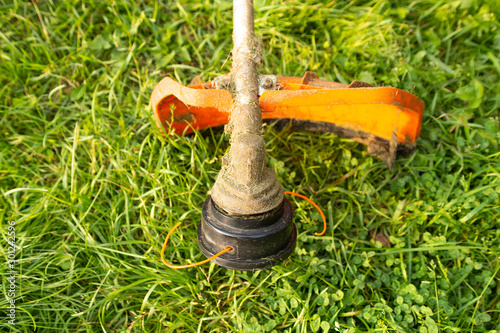 close up of petrol trimmer on grass
