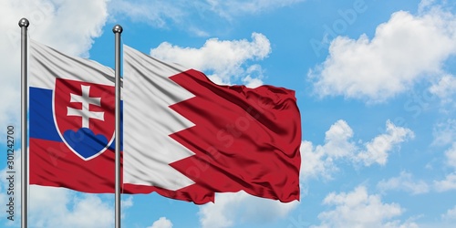 Photography Slovakia and Bahrain flag waving in the wind against white cloudy blue sky together