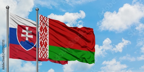 Photography Slovakia and Belarus flag waving in the wind against white cloudy blue sky together