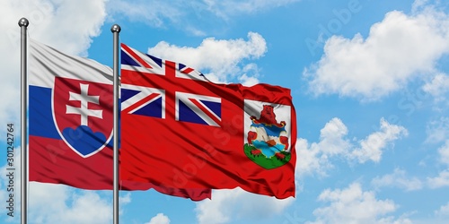 Canvas Print Slovakia and Bermuda flag waving in the wind against white cloudy blue sky together