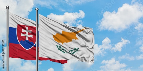 Photography Slovakia and Cyprus flag waving in the wind against white cloudy blue sky together