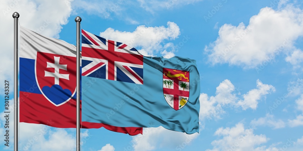 Slovakia and Fiji flag waving in the wind against white cloudy blue sky together. Diplomacy concept, international relations.