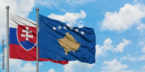Canvas Print Slovakia and Kosovo flag waving in the wind against white cloudy blue sky together