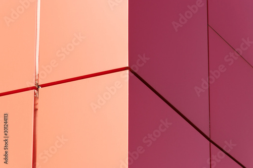 Geometric color elements of the building's facade with planes, lines, corners with highlights and reflections for an abstract background and texture of red, orange colors. Place for text © Тарас Квакуш
