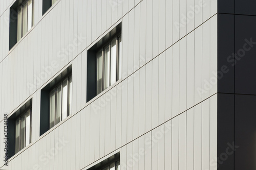 Geometric color elements of the building facade with planes, lines, corners with highlights and reflections for the abstract background and texture of white, gray, blue colors. Place for text