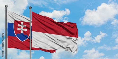 Canvas Print Slovakia and Monaco flag waving in the wind against white cloudy blue sky together