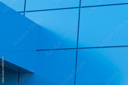Geometric colored building facade elements with planes, lines and corners with light flare and reflections for an abstract background and texture of white, blue, gray colors. Place for text