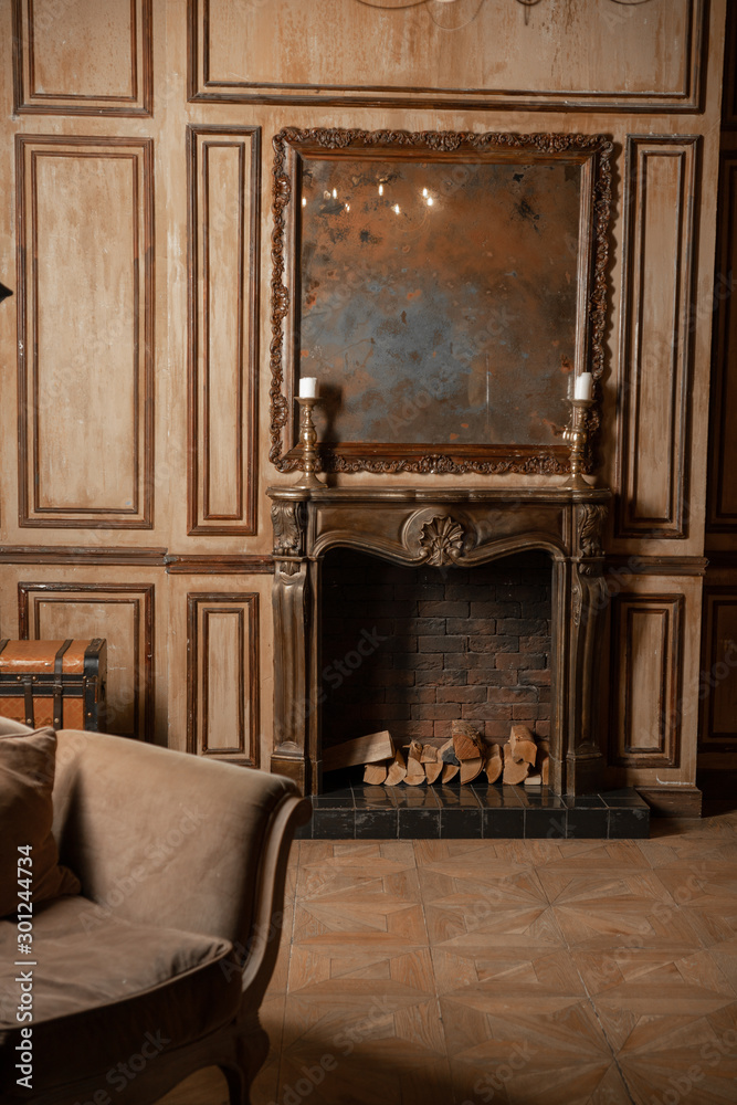 Fototapeta premium A fireplace and an old mirror in the old interior