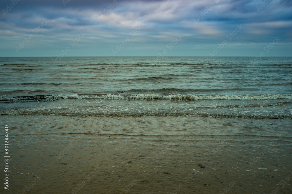 Baltic sea at autumn sunset with green water and dramatic pink sky in Jurmala, Latvia