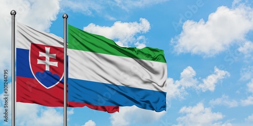 Photography Slovakia and Sierra Leone flag waving in the wind against white cloudy blue sky together