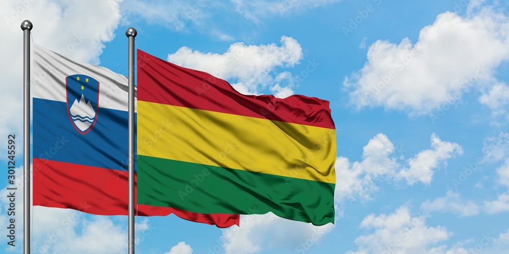 Slovenia and Bolivia flag waving in the wind against white cloudy blue sky together. Diplomacy concept, international relations. Slovenia and Bolivia flag waving in the wind against white cloudy blue sky together. Diplomacy concept, international relations.
