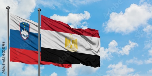 Slovenia and Egypt flag waving in the wind against white cloudy blue sky together. Diplomacy concept, international relations.