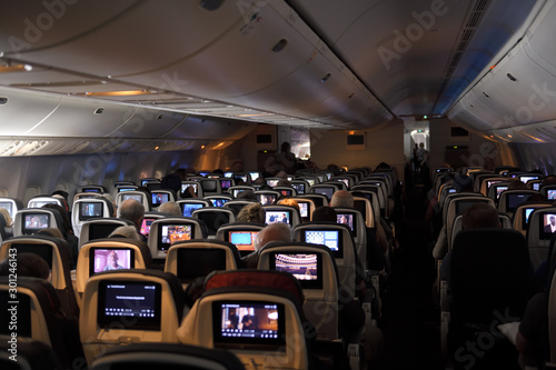 Fotografia Interior of a jet airplane on a long international flight with TV screens on the