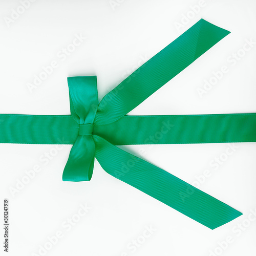 green ribbon with bow on white background.