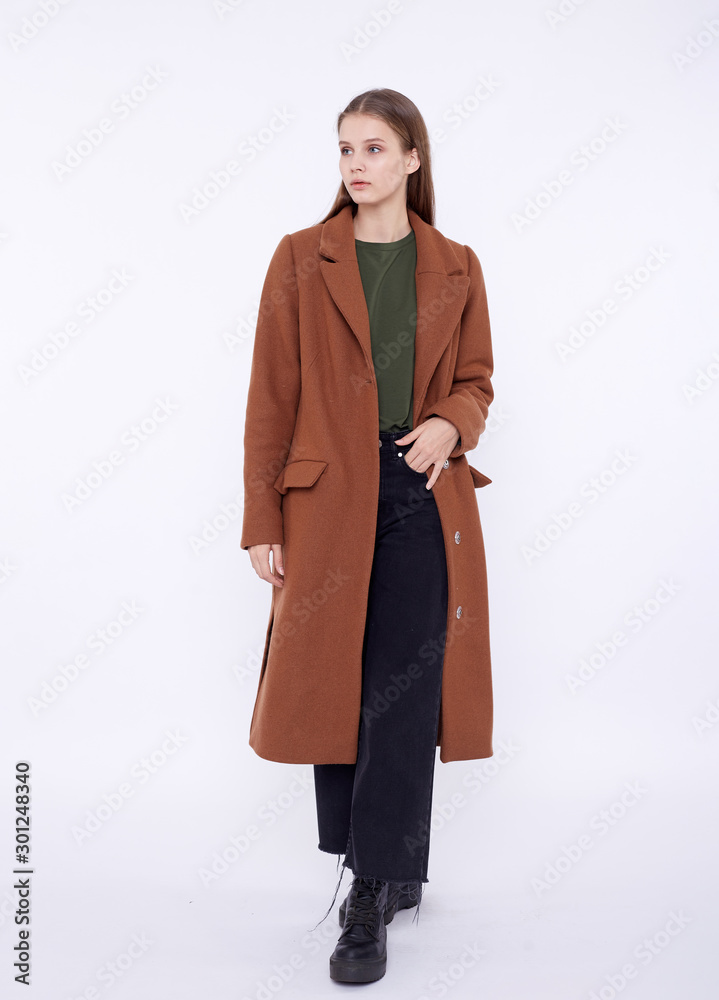 Beautiful fashion model in long brown coat isolated on white background Beautiful fashion model in long brown coat isolated on white background