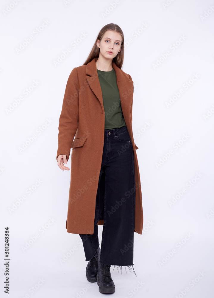 Beautiful fashion model in long brown coat isolated on white background