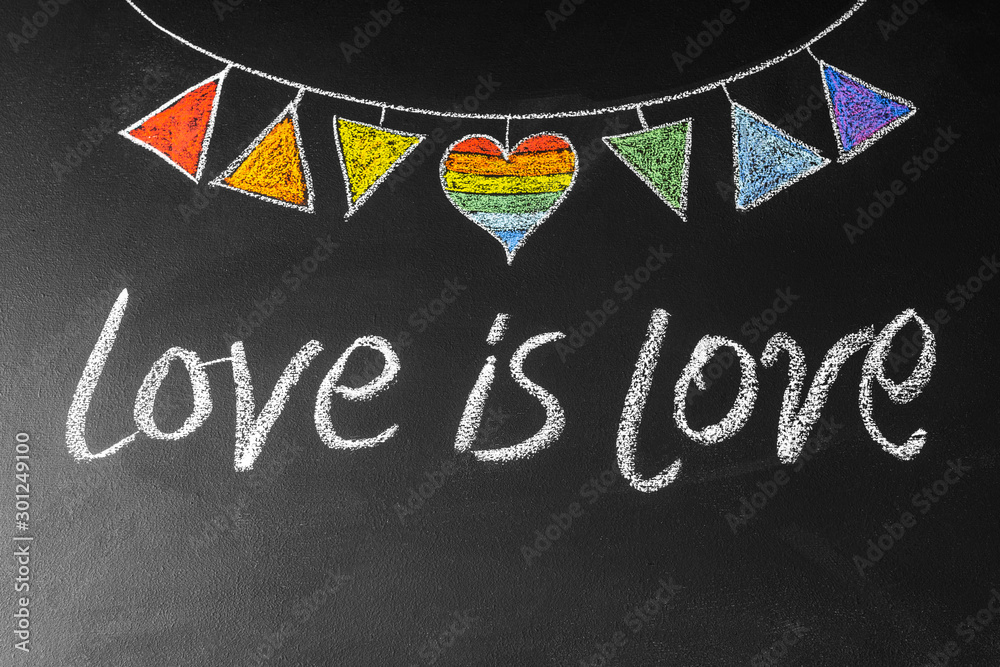 Garland with LGBT symbols drawn on chalk board with inscription love ia love