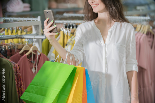 girl in the store with shopping looks at the phone