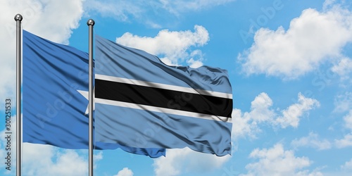 Somalia and Botswana flag waving in the wind against white cloudy blue sky together. Diplomacy concept, international relations.