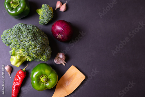 Fototapeta Naklejka Na Ścianę i Meble -  Fresh vegetables, green broccoli, peppers, garlic and onion on a black board