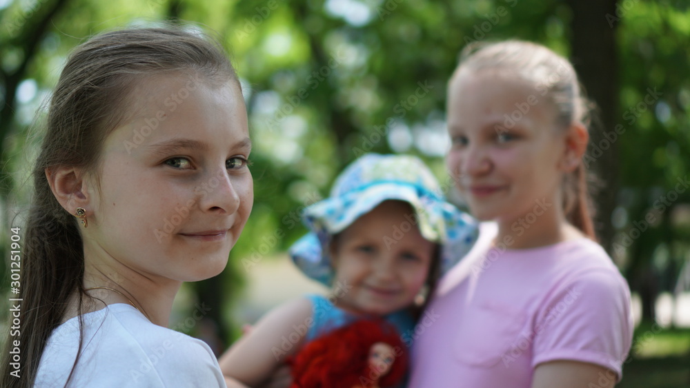 Portrait of three smiling girls posing in a park in the summer Portrait of three smiling girls posing in a park in the summer