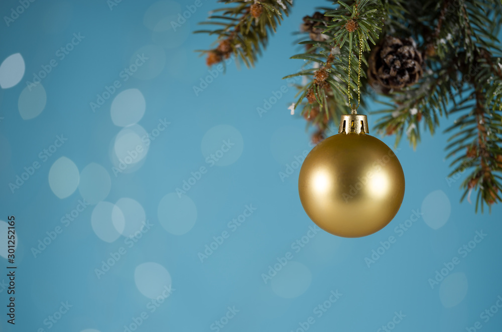 Golden Christmas ball hanging on pine branch Golden Christmas ball hanging on pine branch