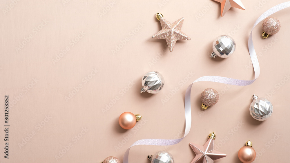 Top view Christmas balls, stars and ribbon on copper or champagne pink background. Flat lay glamour stylish fashion decorations. Elegant Christmas party banner mockup Top view Christmas balls, stars and ribbon on copper or champagne pink background. Flat lay glamour stylish fashion decorations. Elegant Christmas party banner mockup